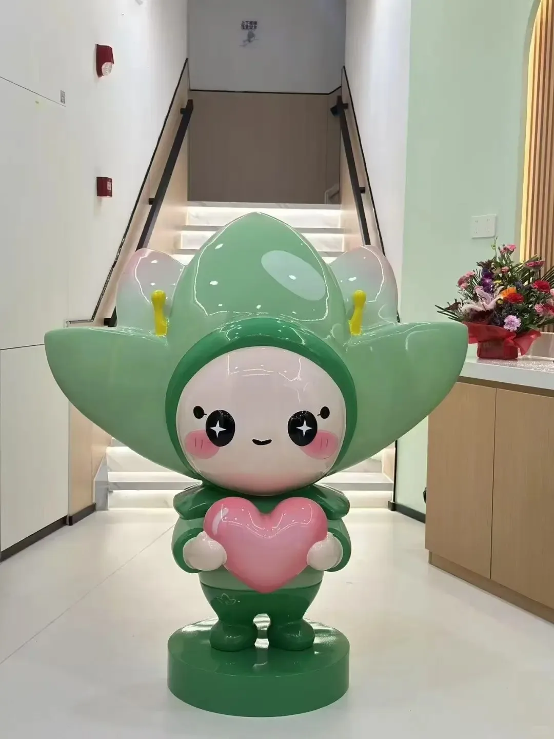 Green Flower Head Mascot FRP Statue with Pink Heart for Store Lobby IP Decor