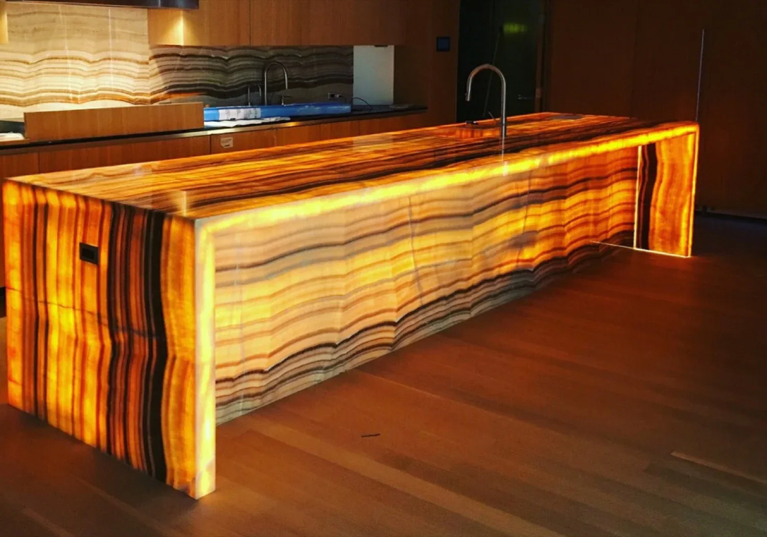 Onyx Counter | Backlit Bars Counters For Sale – Glowing golden onyx bar counter builds warm retro vibe for upscale cocktail l